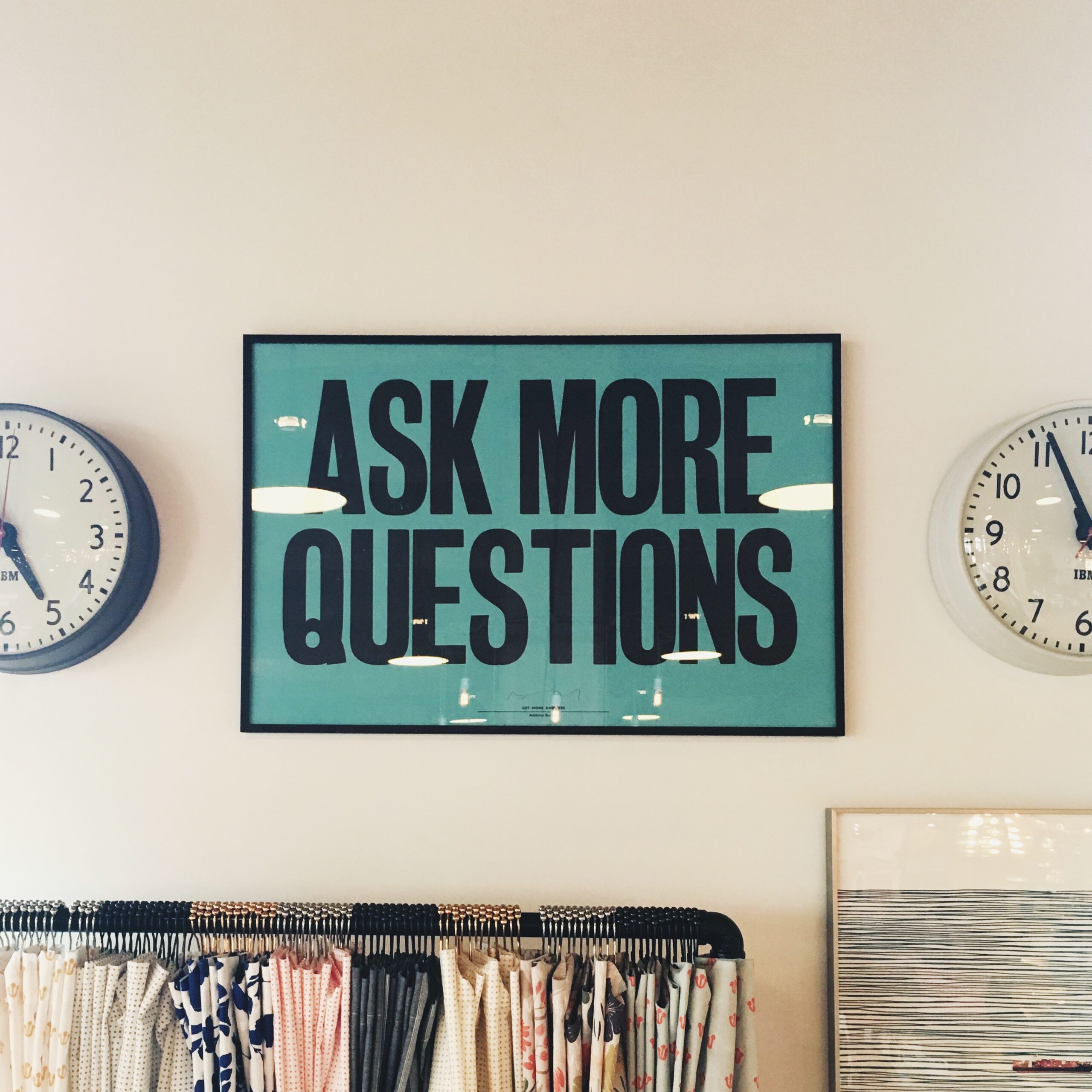 Earn more from clients: a framed print that says 'ask more questions'